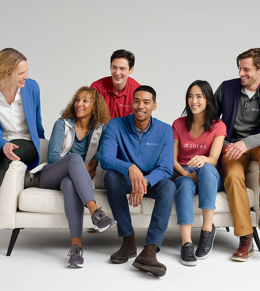 Group of people sitting on a couch wearing custom printed and embroidered apparel from Maverick Printing in Reno.