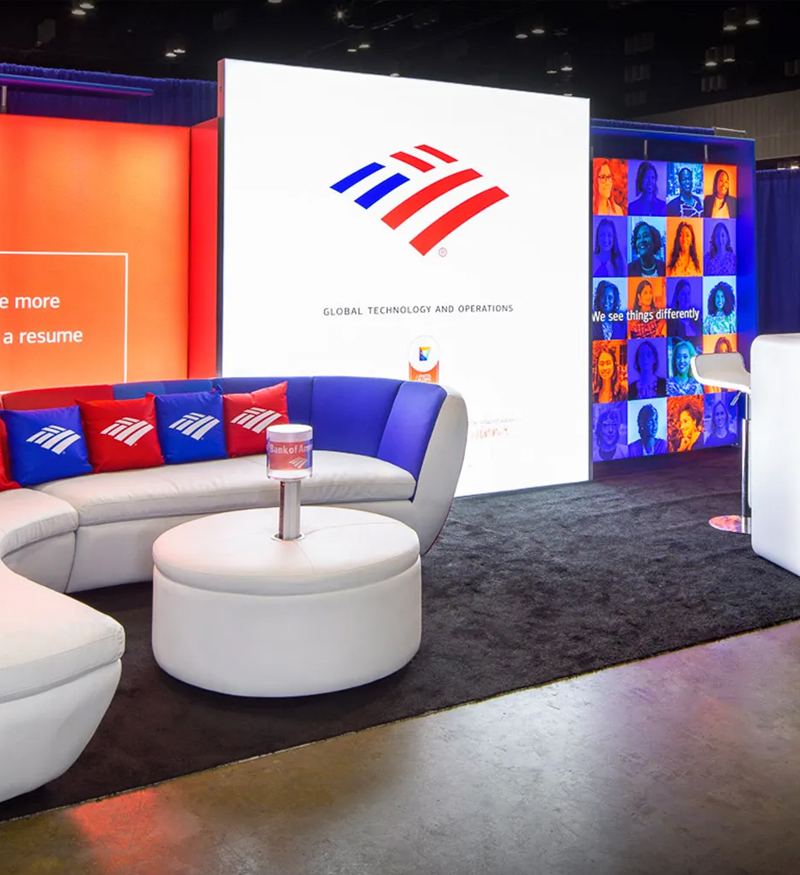 Trade show booth for Bank of America with colorful branded graphics and pillows on a custom couch.