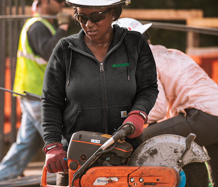Person working in construction site wearing custom printed Carhartt sweatshirt available at Maverick Printing in Reno.