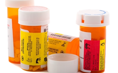 group of prescription medication bottles with custom warning labels.