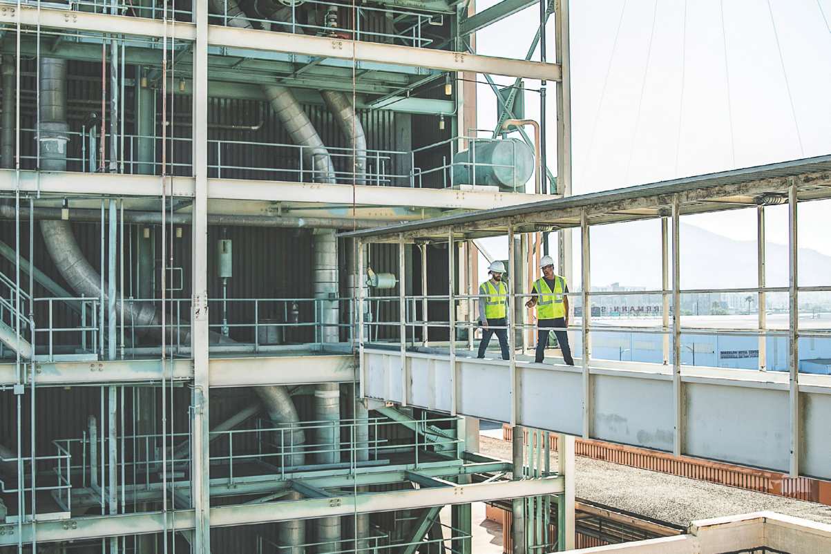 Two people wearing hi-vis safety apparel in construction site.