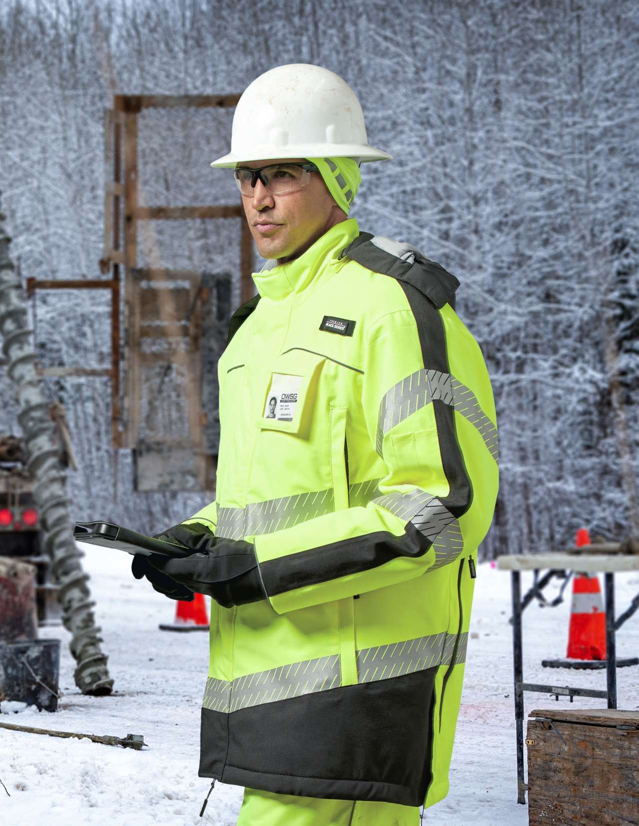 Person wearing green, reflective safety jacket in a frozen outdoor environment.